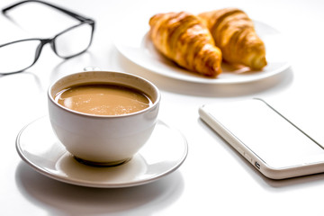 Breakfast for businessman with coffee and croissant on white tab