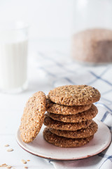 Close up of baked wholegrain cookies on white wooden table with milk on background