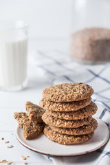 Close up of baked wholegrain cookies on white wooden table with milk on background