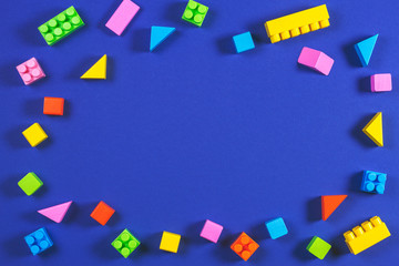 Baby kid toys background. Colorful plastic construction blocks and wooden cubes on blue background