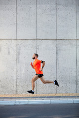 Fototapeta na wymiar Young bearded man running on the street. Healthy lifestyle concept.