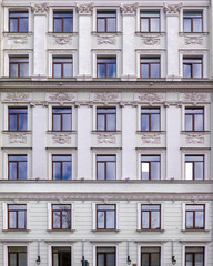 Vintage architecture classical facade apartment building decorated stucco moulding in Enpire style.  Front view
