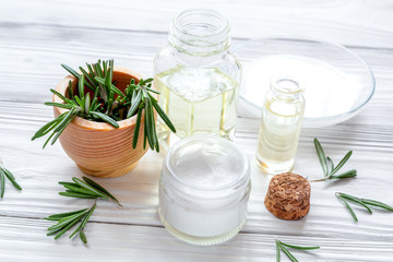 Fototapeta na wymiar organic cosmetics with extracts of herbs rosemary on wooden back