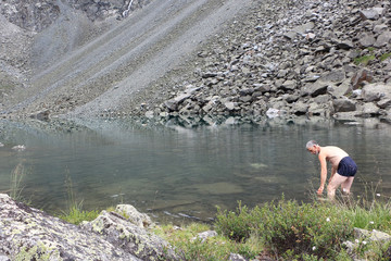 Undressed man washing in Lake Mountain Spirits, Altai Mountains, Russia