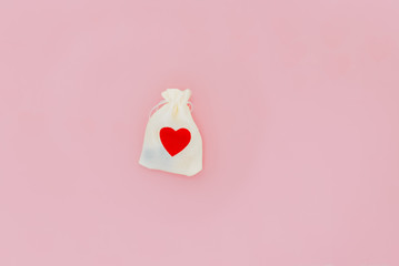 White bag with red hart on a pink backgound. Snt Valentines day, 14 February and love day. Love...
