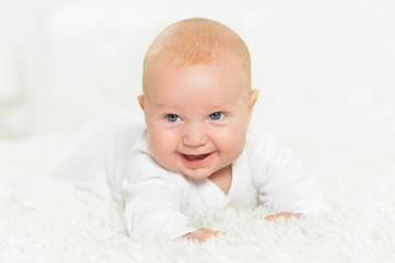 Portrait of cute beautiful baby boy on bed
