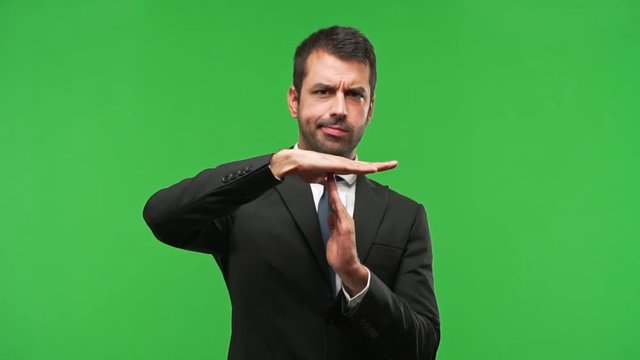 businessman making stop gesture with her hand to stop an act  on green screen chroma key background