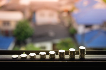 Row of coin money on wood table with city background, Real Estate market, Economy, Mortgage, Investment Concepts