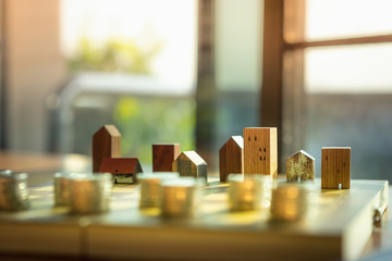 Wood house model and row of coin money on wood table, Real Estate market, Trading Estate, Mortgage Concepts