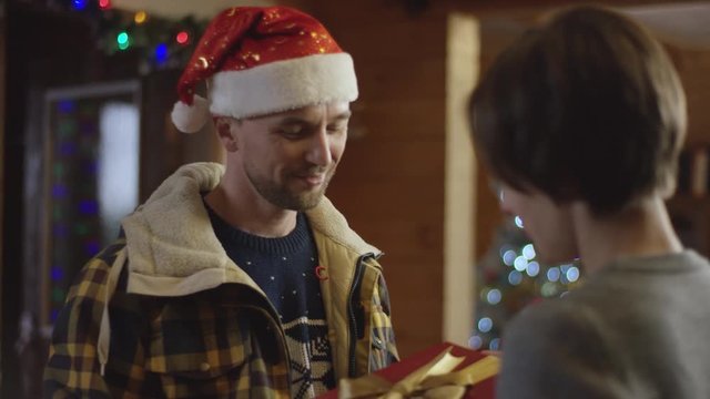 Husband gives a Christmas gift to his wife and comes inside the house