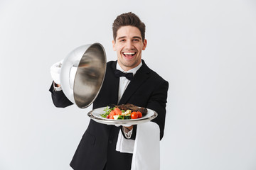 Portrait of a handsome young waiter in tuxedo