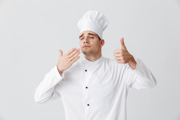 Cheerful chef cook wearing uniform tasting the smell