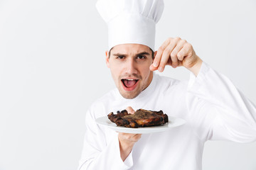 Cheerful chef cook wearing uniform peppers