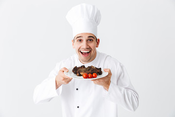 Cheerful chef cook wearing uniform peppers