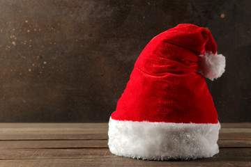 Red Santa Claus hat standing on a dark brown background. with space for text. Christmas. new Year.
