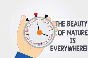 Naklejka premium Handwriting text writing The Beauty Of Nature Is Everywhere. Concept meaning Natural scenes are in all the places Hu analysis Hand Holding Mechanical Stop Watch Timer with Start Stop Button