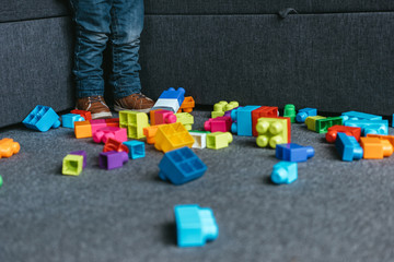 cropped image of boy playing with colorful plastic blocks at home