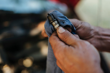 Man checks the spark plug on the old car