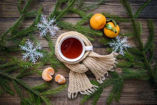 Christmas picture on a wooden background, cup of tea in scarf