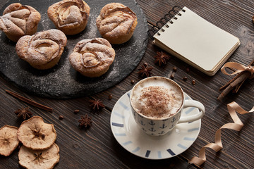 notebook, muffins on black plate, notepad, cappuccino cup