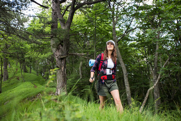 Young female hiker with backpack in a forest