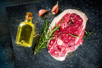 Raw meat, beef or lamb steak with bone, for grilling, with spices and herbs, top view place for text
