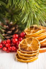 Greeting card for congratulations Merry Christmas with fir cones, dry lemon on a white wooden background with place for text