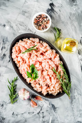 Homemade minced chicken meat in black bowl on concrete background with ingredients for cooking.Top view copy space.