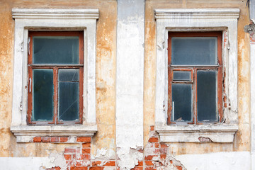 windows in an old house with damaged brick walls