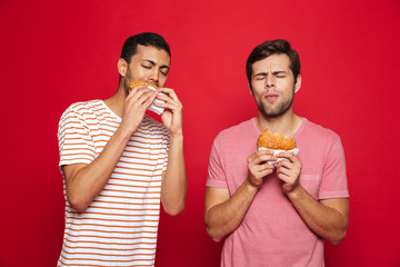 Two delighted men friends standing isolated