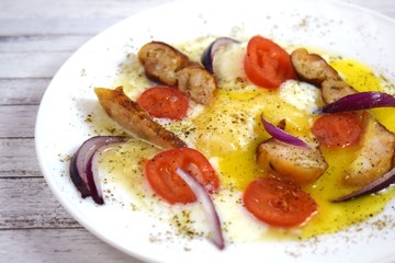 Delicious scrambled eggs with tomatoes and sausages for Breakfast.