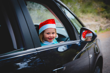 christmas car travel- happy little girl loves travel in winter