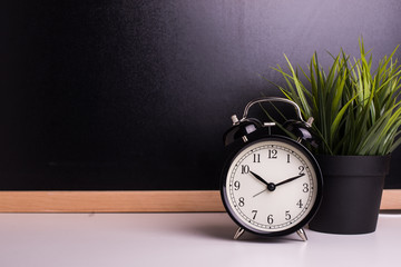 vintage alarm clock on the background of a blackboard