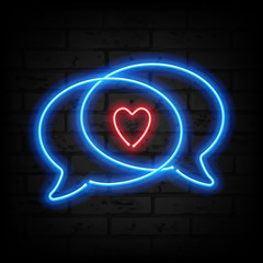Neon heart and speech bubbles on brick wall.