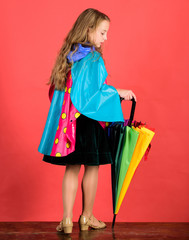 Kid girl happy hold colorful umbrella wear waterproof cloak. Enjoy rainy weather with proper garments. Waterproof accessories make rainy day cheerful and pleasant. Waterproof accessories manufacture