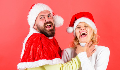 Man with beard and woman in santa hat on red background. Couple celebrate winter holiday christmas....