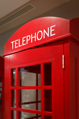 Traditional red telephone booth stands indoors as a symbol of London and the UK