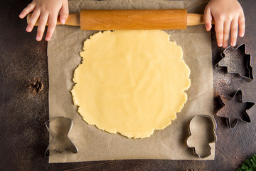 Children is cooking Christmas cookies, roll out the dough, family tradition, tasty sweet holiday food