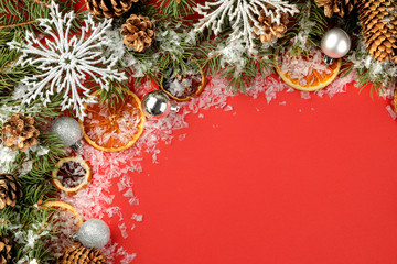 Christmas and New Year frame for text with a Christmas tree and colored Christmas decorations on a red bright background. view from above.