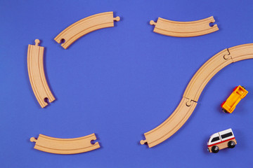 Toy train and wooden rails pieces on blue color background