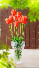 vase with red tulips outdoors