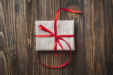 gift with red ribbon on the wooden table