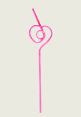 pink straw in the shape of a heart for a cocktail, isolated
