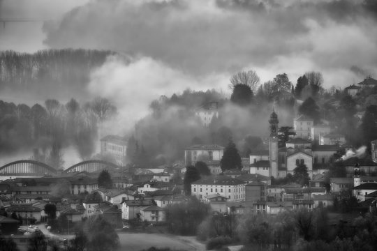 Alba con nebbia sul paesi di Brivio, Lombardia, Italia