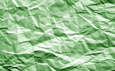 Crumpled sheet of paper in green color.