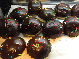 Chocolate coating donut deep fried donut in cinnamon sugar coating and chocolate glazed sprinkle with 100’s and 1000’s 
