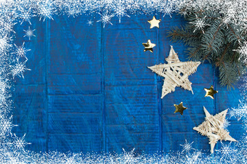 Christmas background. gold stars decorations on blue wooden background. Top view copy space. Snow...