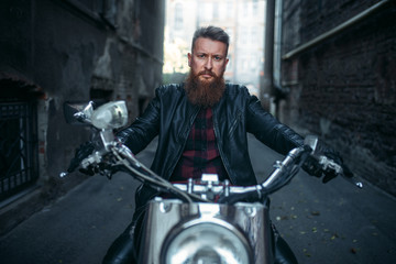 Fototapeta premium Bearded biker on classical chopper, front view