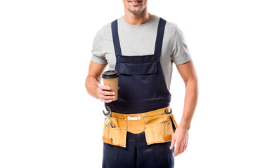 partial view of worker with tool belt drinking coffee to go isolated on white