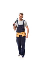 serious plumber in overalls holding pipe wrench isolated on white
